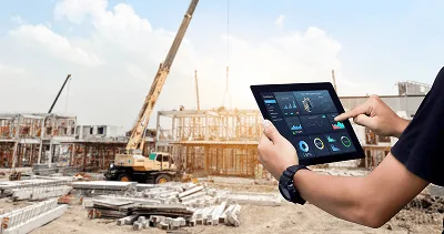 10 Unmistakable Signs Your Construction Team Needs to Invest in Construction Software 2 A person uses a tablet to monitor project data on an active construction site — 10 Unmistakable Signs Your Construction Team Needs to Invest in Construction Software image