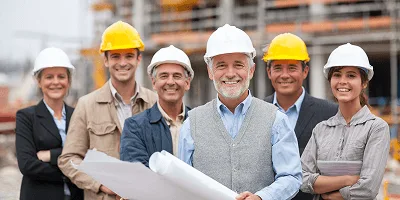 How to Promote a Construction Company? 3 A confident construction team in safety helmets stands together at a building site — How to Promote a Construction Company article