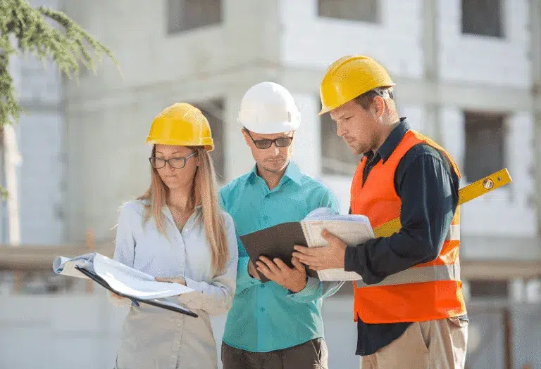 Blog 14 Three construction professionals review project documents together on-site — How to Deliver Accurate Construction Estimates