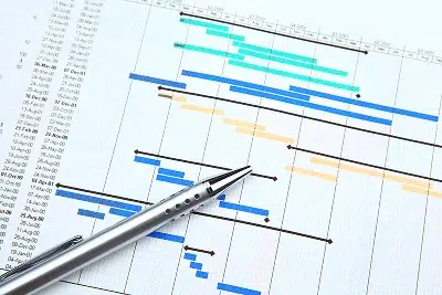 10 Tips for Completing Construction Projects On Time and On Budget 1 A close-up of a Gantt chart with a pen resting on the project timeline — 10 Tips for Completing Construction Projects On Time and On Budget article